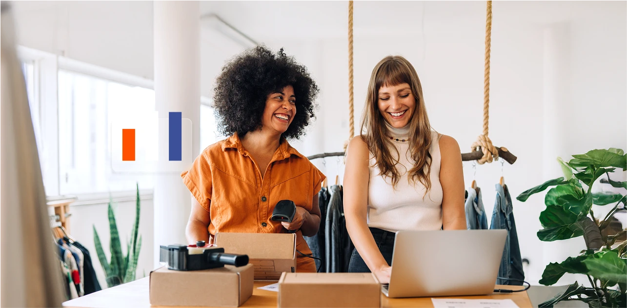 A photo of two women, one working on a laptop and the other scanning products.