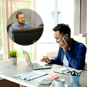 Photo of man talking on a phone to support while working on his laptop